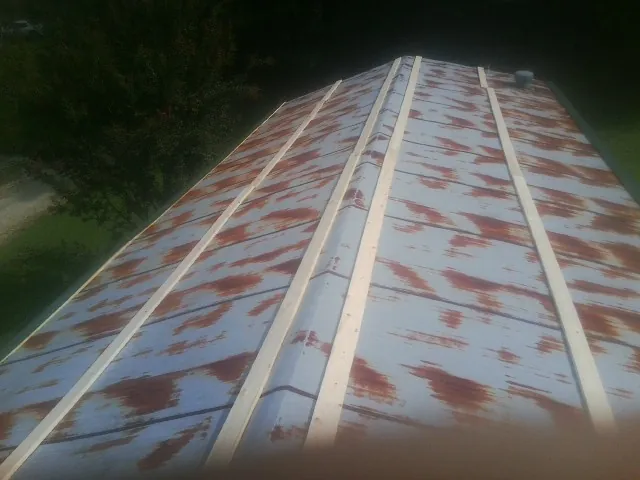 Rusted metal roof panels with new wood purlins before replacement — Storm Damage Roof Repair in Medicine Bow by Roofing Brothers
