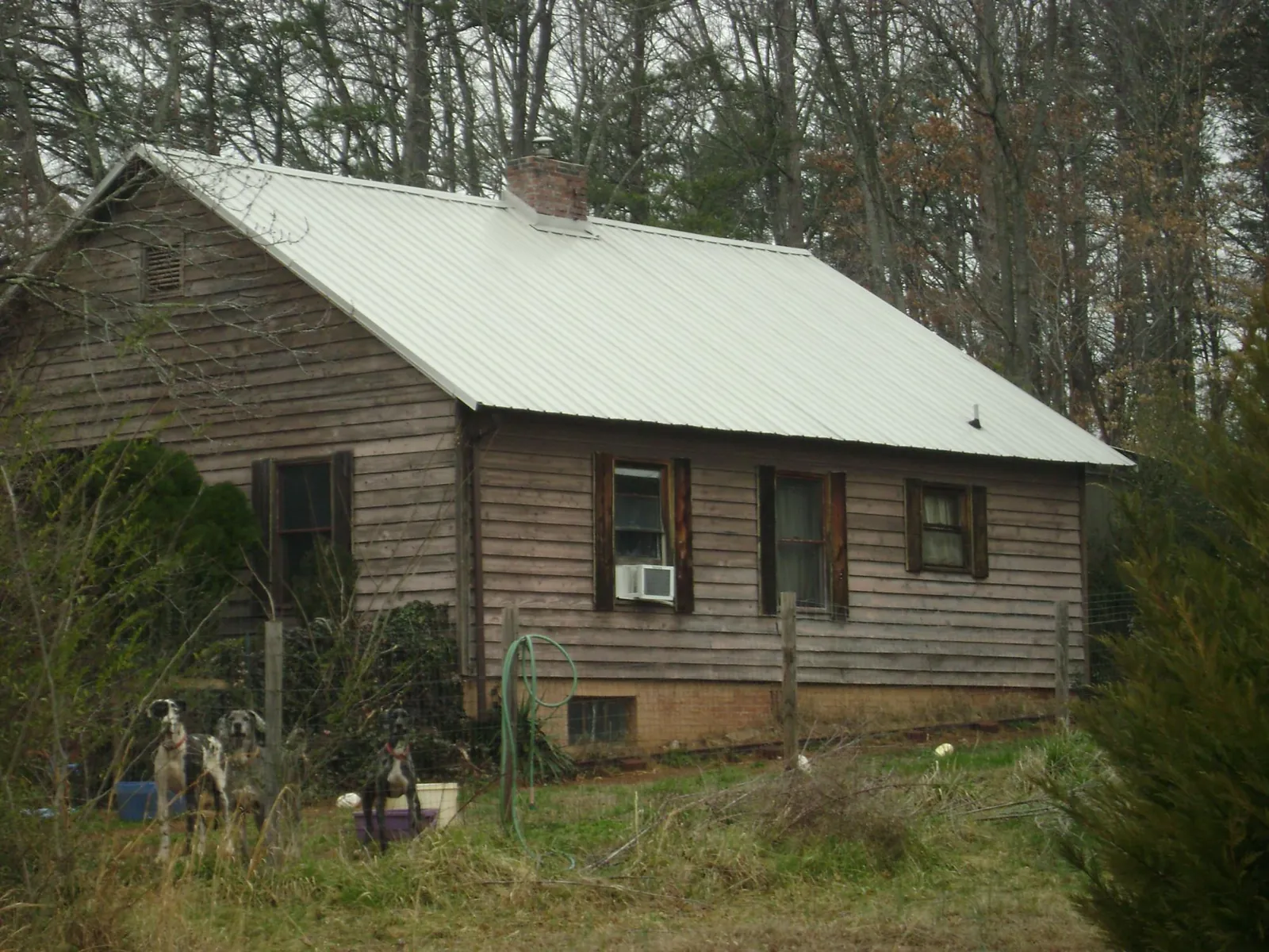White metal roof on an old wood sided farmhouse, from a Metal Roof Installation job in Medicine Bow